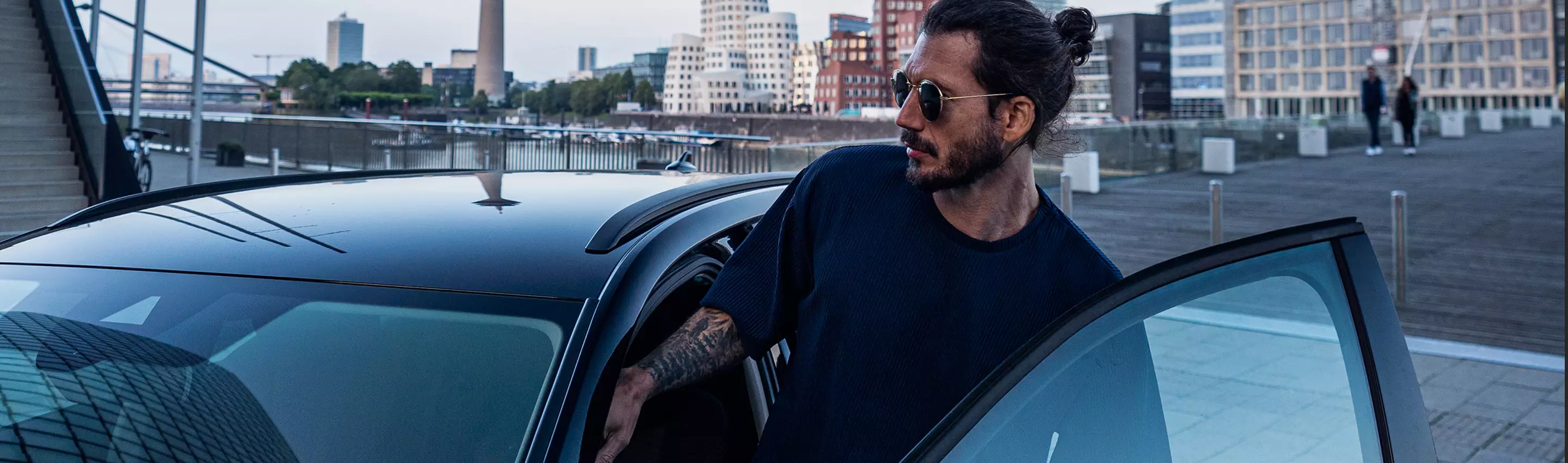 Ein Mann steigt in sein Auto ein um es zu einem Händler zum Autoverkauf zu bringen.