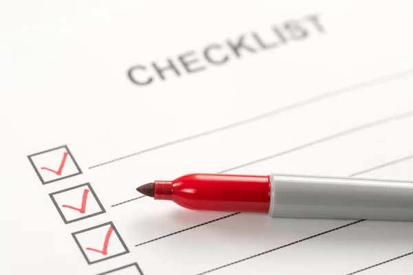 Checkliste mit roten Haken und einem roten Filzstift